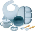 Blue silicone baby feeding set including bib, plate, cup, and utensils on a white background